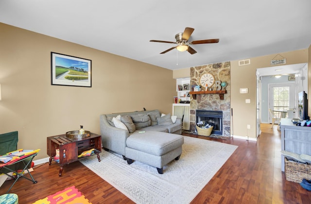 4662 Nibbs Ln, North Charleston, SC 29418 - living area with a ceiling fan, dark wood-type flooring, a stone fireplace, and baseboards