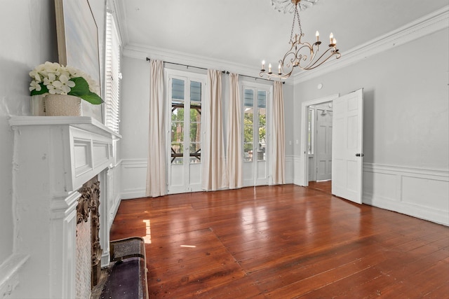 unfurnished living room featuring a notable chandelier, dark hardwood / wood-style flooring, and ornamental molding