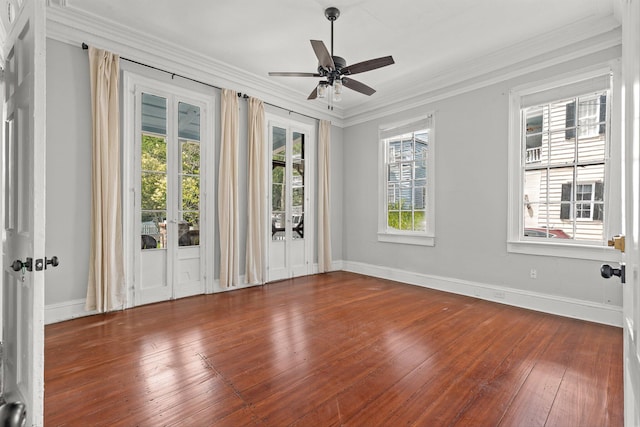 spare room with a wealth of natural light, ceiling fan, crown molding, and hardwood / wood-style flooring