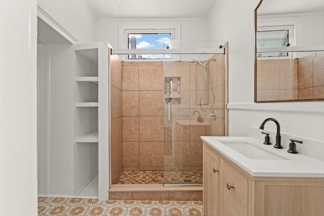 bathroom with built in shelves, vanity, tile patterned floors, and a shower with door