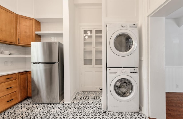 washroom with light wood-type flooring and stacked washer and dryer