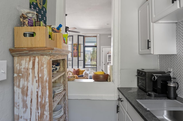 kitchen with white cabinetry, backsplash, and ceiling fan