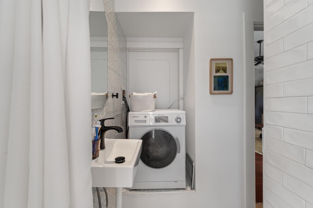 clothes washing area with washer / clothes dryer and sink