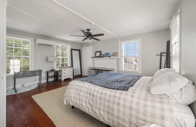 bedroom with ceiling fan, multiple windows, and a wall mounted air conditioner