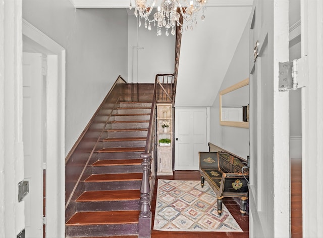 stairs with hardwood / wood-style flooring and a notable chandelier