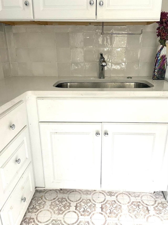 interior space featuring tile patterned flooring, sink, and backsplash