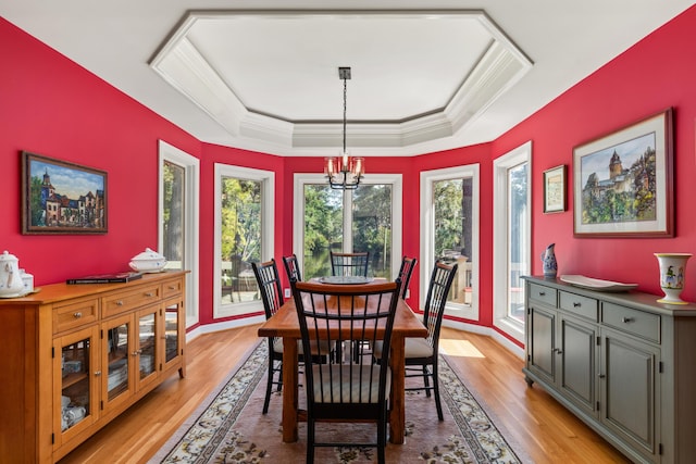 2105 Loblolly Ln, Seabrook Island, SC 29455 - dining room featuring a tray ceiling, light wood-style floors, a chandelier, and crown molding