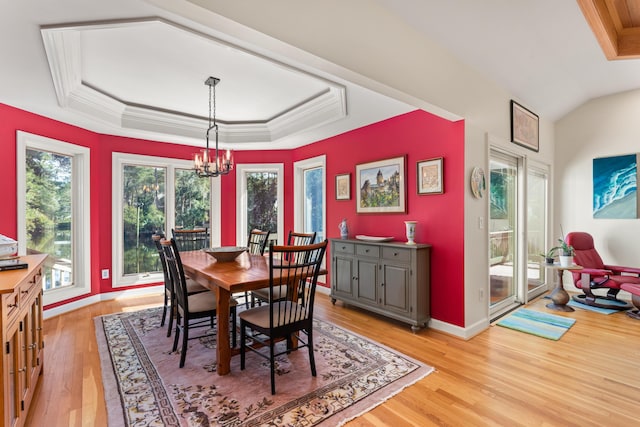 2105 Loblolly Ln, Seabrook Island, SC 29455 - dining space with a raised ceiling, light wood-style flooring, a chandelier, baseboards, and crown molding