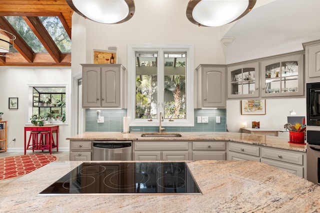 2105 Loblolly Ln, Seabrook Island, SC 29455 - kitchen with dishwasher, a sink, black electric cooktop, backsplash, and light stone counters