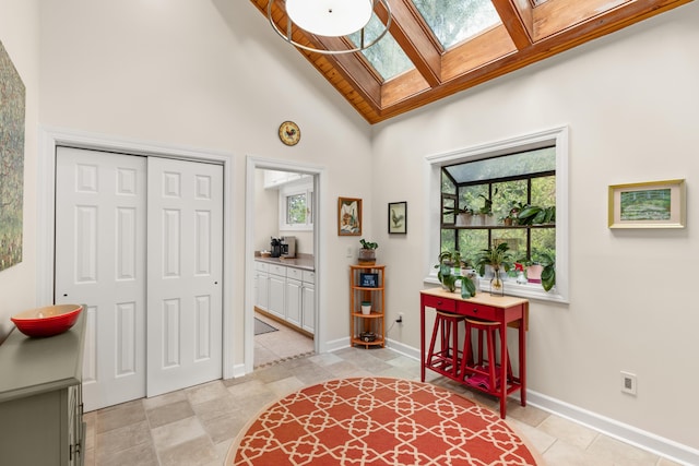 2105 Loblolly Ln, Seabrook Island, SC 29455 - foyer entrance featuring a skylight, high vaulted ceiling, and baseboards