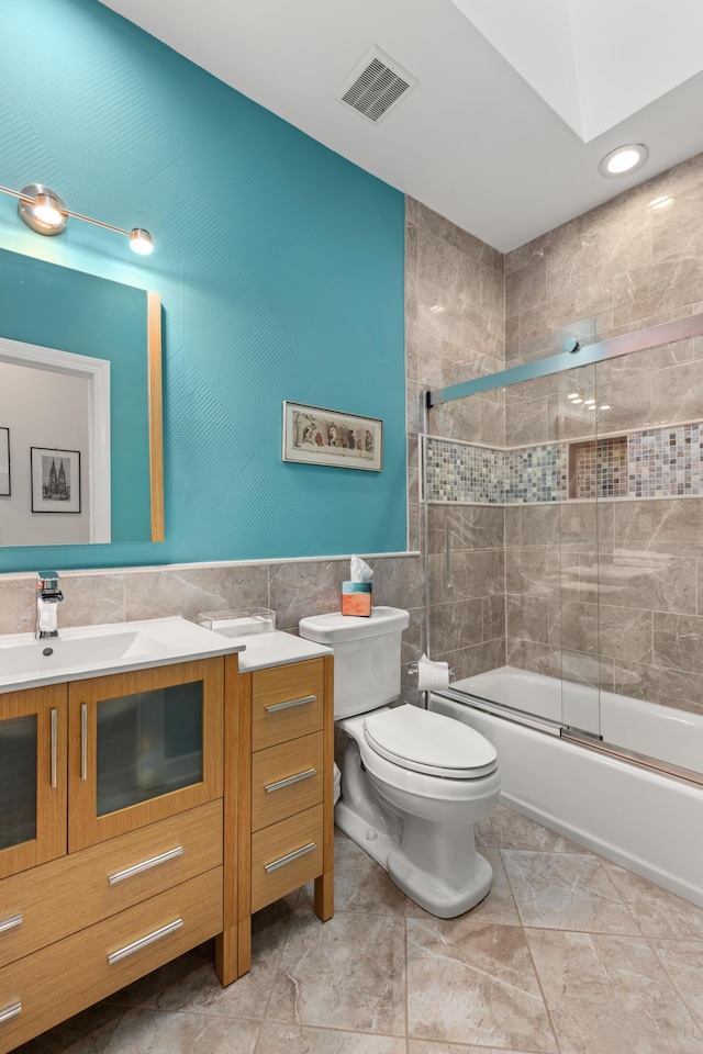 2105 Loblolly Ln, Seabrook Island, SC 29455 - bathroom featuring vanity, tile walls, toilet, enclosed tub / shower combo, and recessed lighting