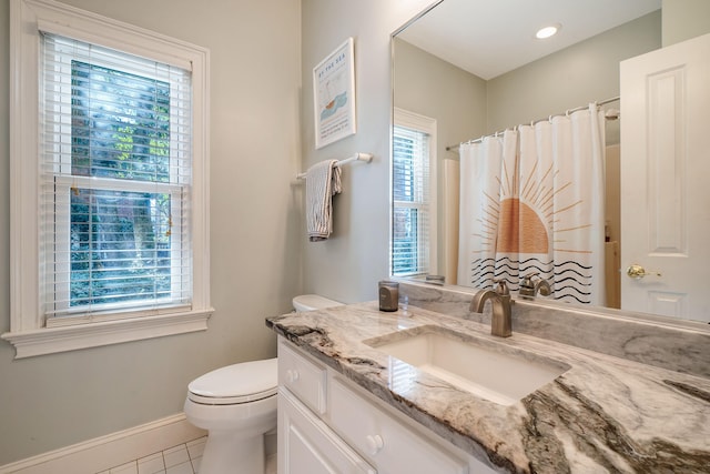 bathroom featuring tile patterned flooring, vanity, toilet, and a healthy amount of sunlight