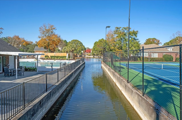 view of home's community featuring a water view and tennis court