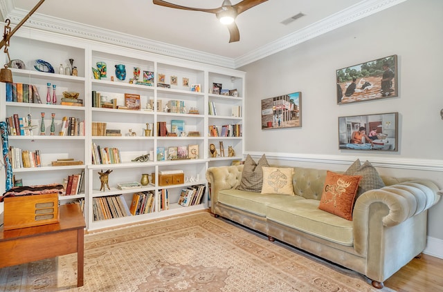 living area with ceiling fan, light hardwood / wood-style flooring, and ornamental molding