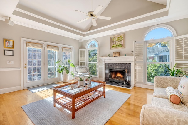 living room featuring light wood-type flooring, crown molding, and a wealth of natural light