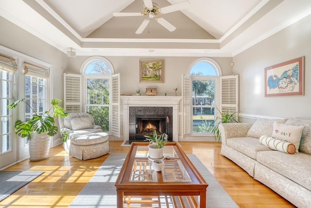 living room with a wealth of natural light, crown molding, and light wood-type flooring