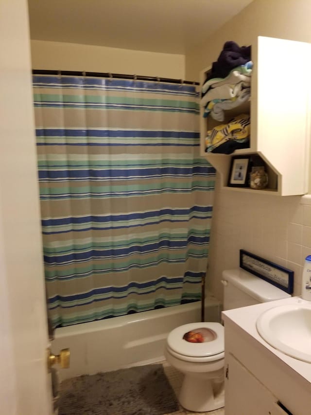 full bathroom featuring vanity, shower / tub combo with curtain, tile walls, toilet, and tasteful backsplash