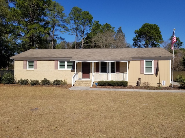 single story home with a front yard and covered porch