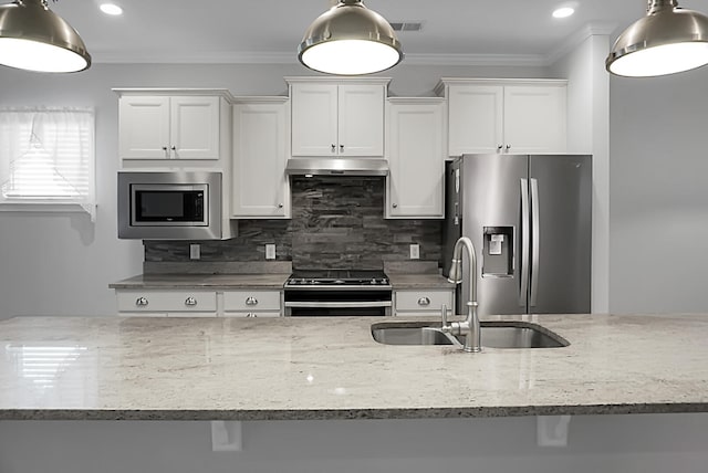 kitchen featuring light stone countertops, white cabinetry, sink, stainless steel appliances, and tasteful backsplash