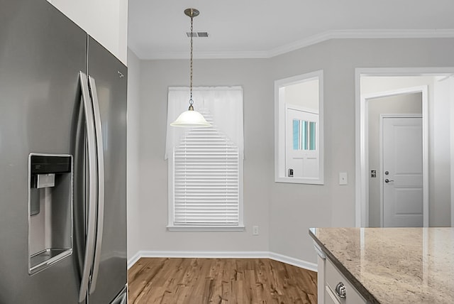 kitchen with stainless steel refrigerator with ice dispenser, light stone counters, crown molding, light hardwood / wood-style floors, and hanging light fixtures