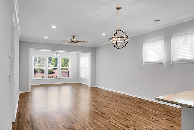 interior space with hardwood / wood-style floors, ceiling fan with notable chandelier, and ornamental molding