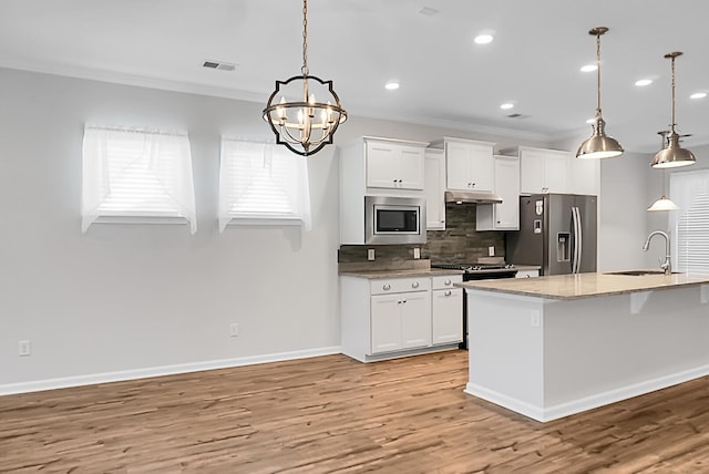 kitchen featuring white cabinetry, sink, stainless steel appliances, and decorative light fixtures