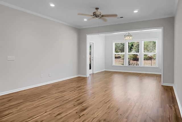 unfurnished room with crown molding, ceiling fan with notable chandelier, and hardwood / wood-style flooring