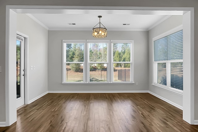 unfurnished dining area featuring ornamental molding, dark hardwood / wood-style flooring, and a notable chandelier