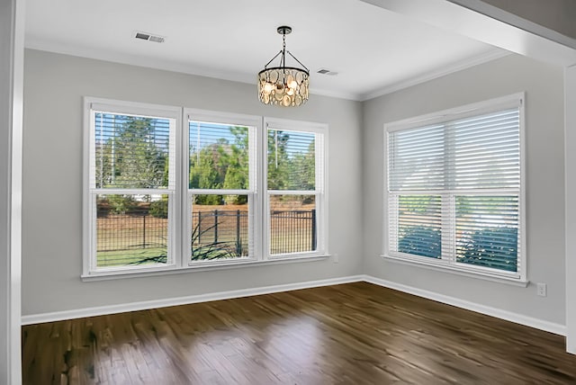 unfurnished dining area with dark hardwood / wood-style flooring, plenty of natural light, ornamental molding, and a notable chandelier