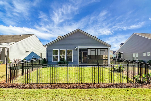 back of property with a sunroom and a yard