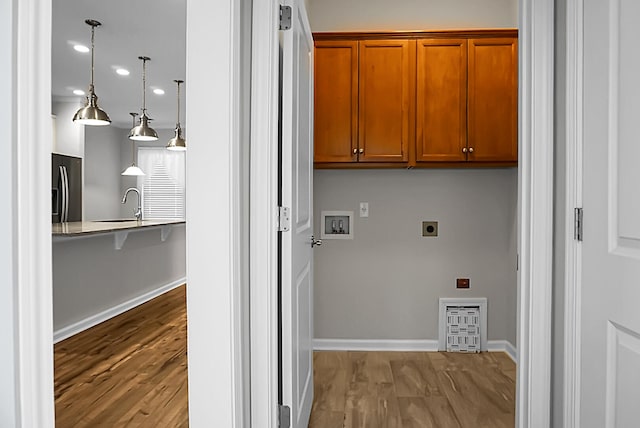 laundry area featuring light hardwood / wood-style floors, washer hookup, cabinets, and hookup for an electric dryer