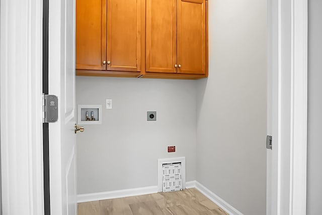 washroom with cabinets, washer hookup, light hardwood / wood-style floors, and hookup for an electric dryer