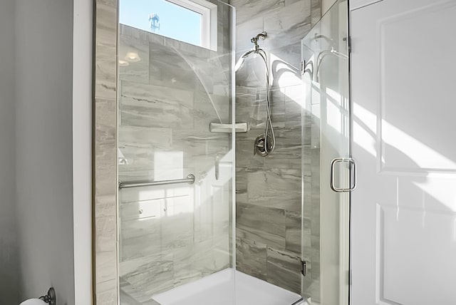 bathroom with a shower with door