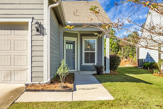 doorway to property featuring a garage, central air condition unit, and a yard