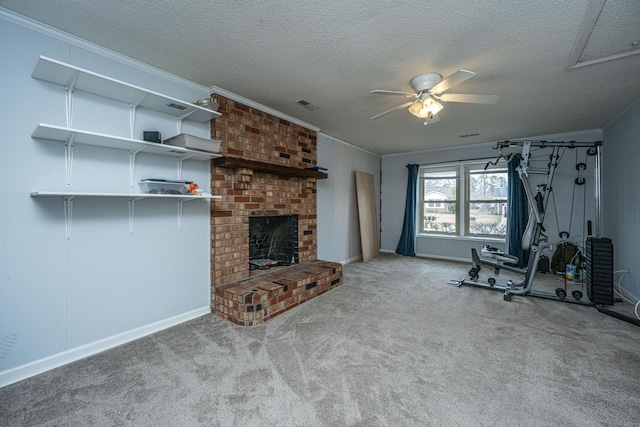 exercise area featuring crown molding, a fireplace, a textured ceiling, and ceiling fan