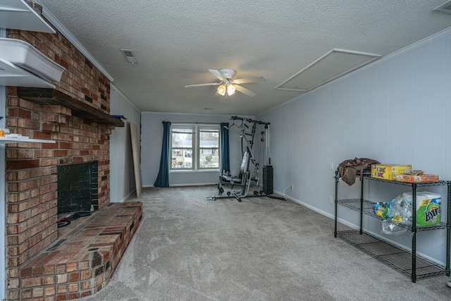 workout area featuring ceiling fan, carpet floors, ornamental molding, a textured ceiling, and a brick fireplace