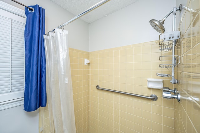 bathroom with a shower with shower curtain and a textured ceiling