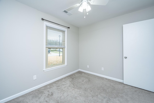 carpeted spare room featuring ceiling fan