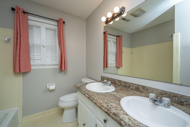 full bathroom featuring toilet, shower / bathing tub combination, a textured ceiling, vanity, and tile patterned flooring