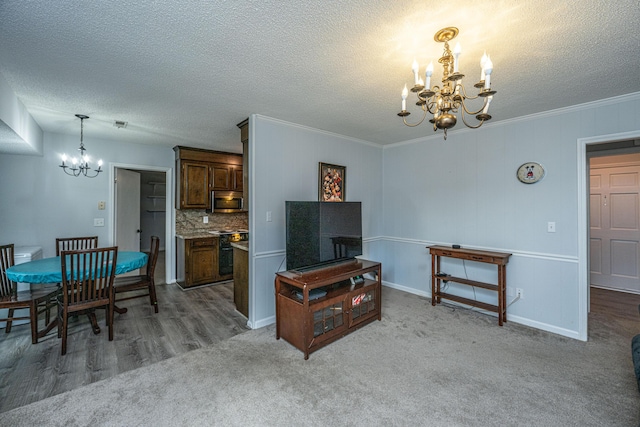 carpeted living room with crown molding, a textured ceiling, and a notable chandelier