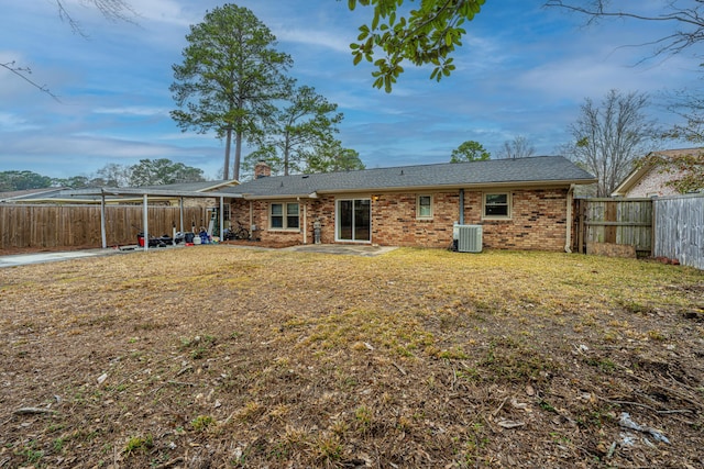 rear view of house with central AC unit and a lawn