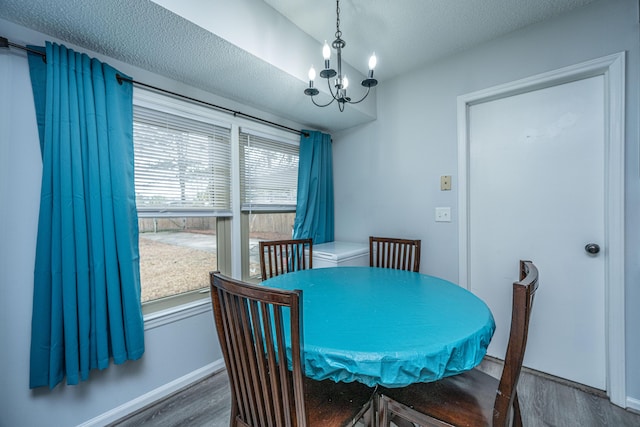 dining space with an inviting chandelier, hardwood / wood-style floors, and a textured ceiling