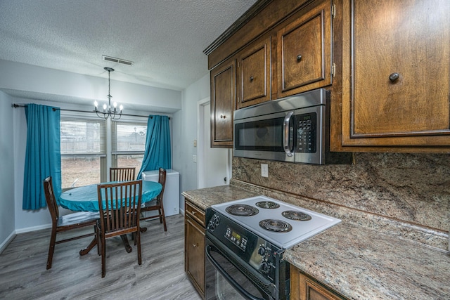 kitchen with an inviting chandelier, backsplash, light hardwood / wood-style floors, black range with electric stovetop, and a textured ceiling