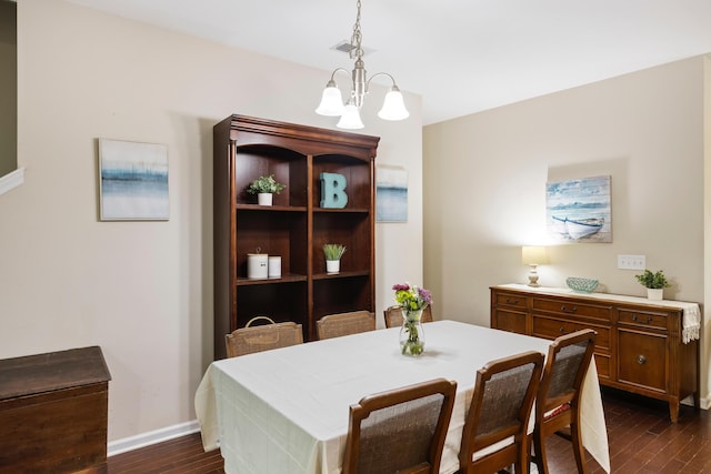 dining area featuring dark wood finished floors, baseboards, and a chandelier
