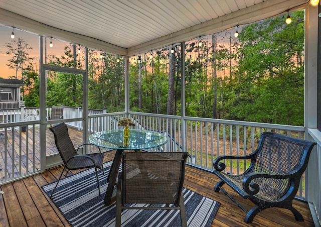 sunroom / solarium featuring outdoor dining space