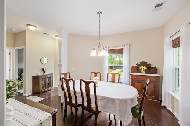 dining area with a chandelier, dark wood-style floors, and baseboards