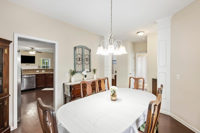 dining room with dark wood-style floors, a chandelier, a ceiling fan, and baseboards