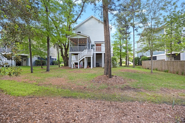 rear view of property featuring a sunroom and stairs
