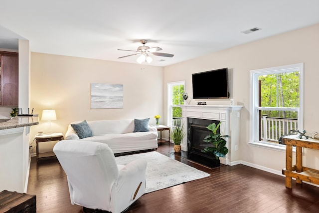 living room with healthy amount of natural light and dark wood-style flooring