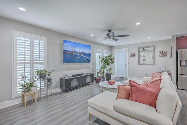 living area with light wood-type flooring, recessed lighting, and baseboards